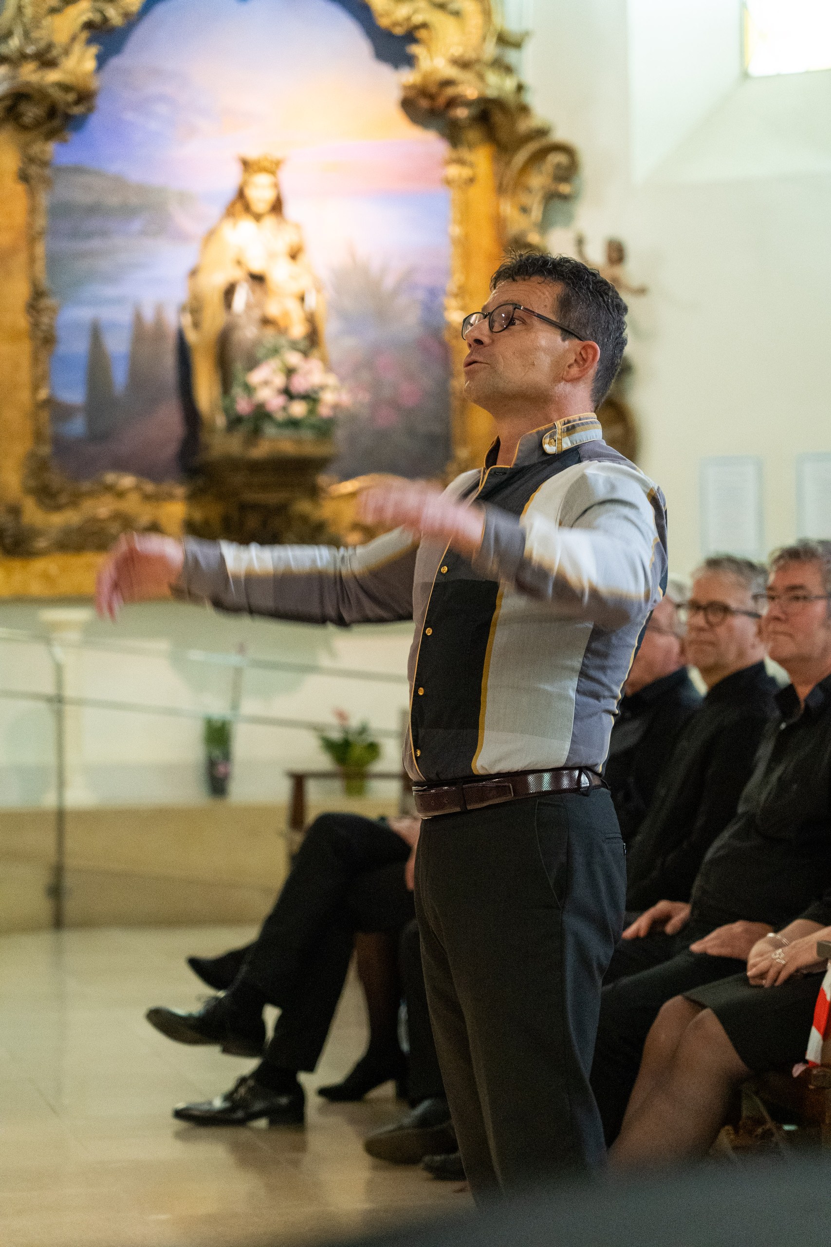 A conductor leading a choir in a church, SGP and WGP festival archive, 2025.